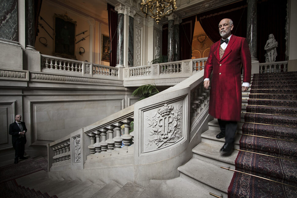 Na zdjęciu mężczyzna schodzący po schodach w pałacu.